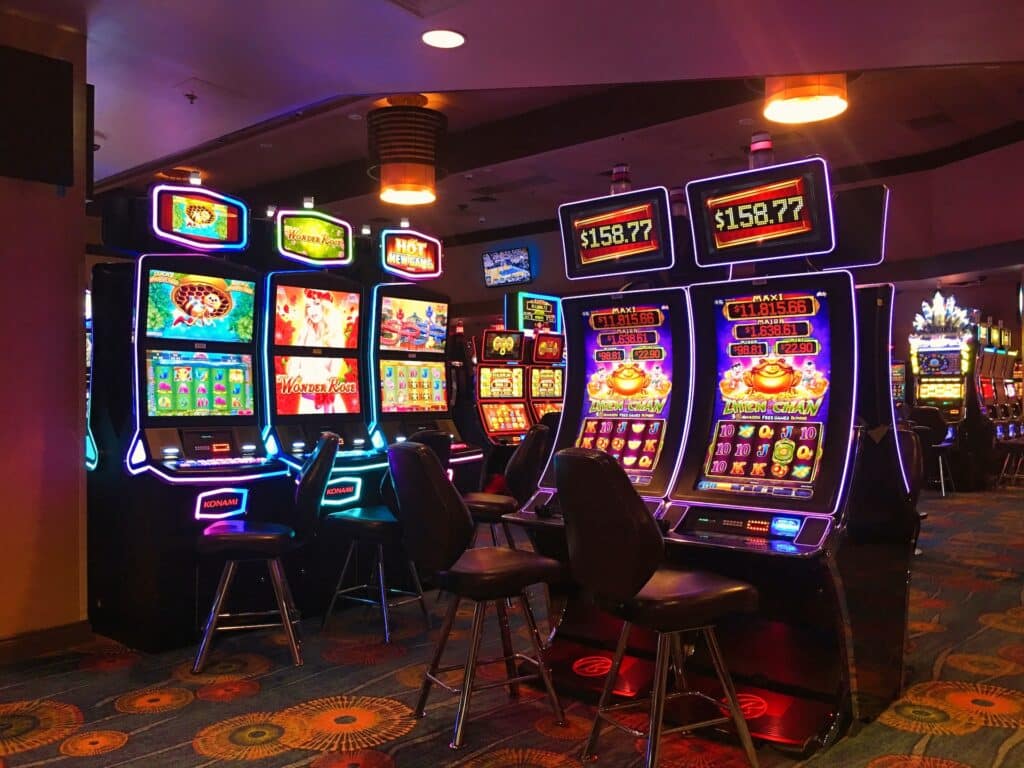 Ambijent kazina, ispunjen slot aparatima, svetlima i stolicama