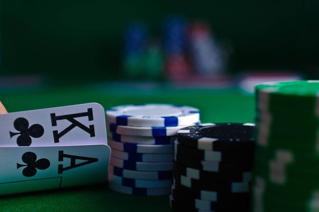 Karte za poker, kralj i as pokraj naslaganih čipova