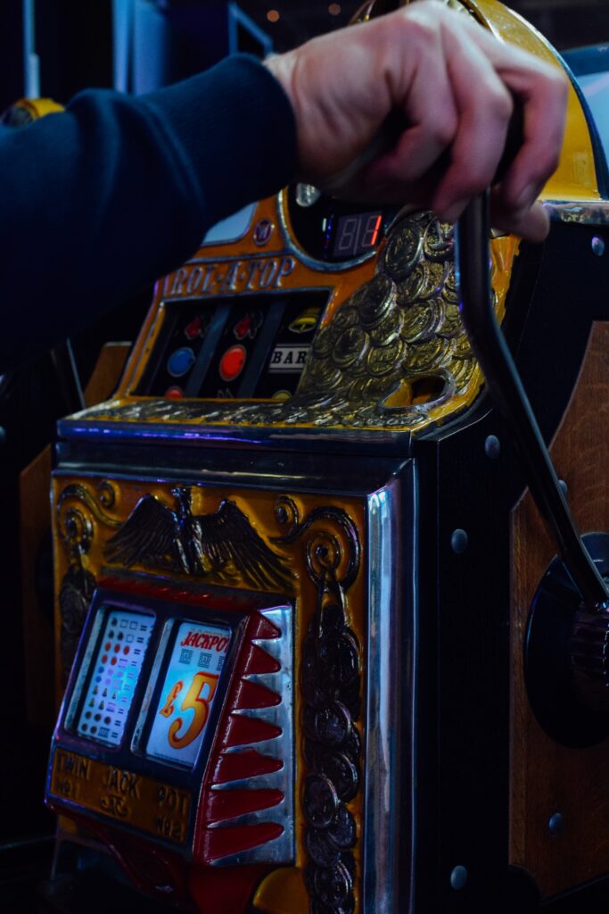 Ruka povlači ručicu na slot mašini za kockanje