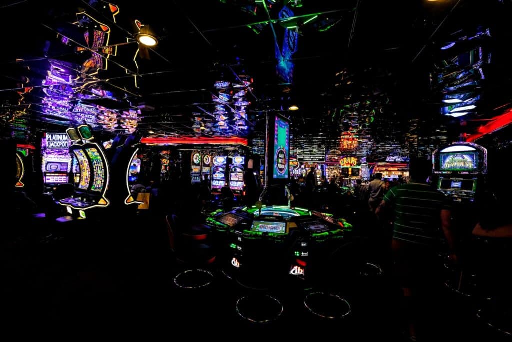Mračni ambijent kazina sa mnogo svetlećih ekrana