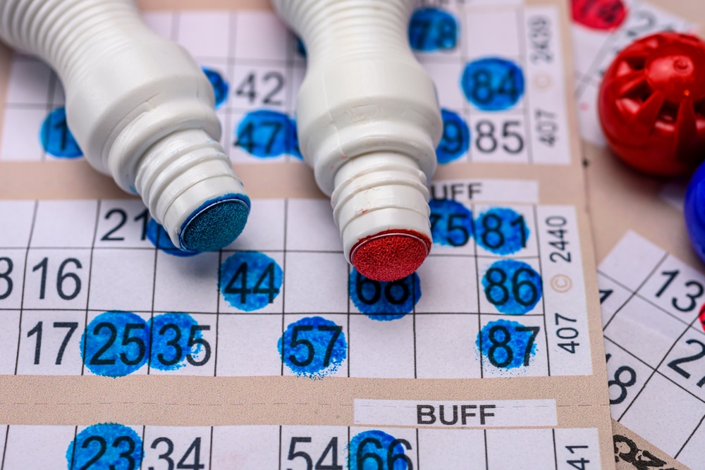 Listić koji pokazuje kako se igra bingo sa označenim brojevima, crveni i plavi marker
